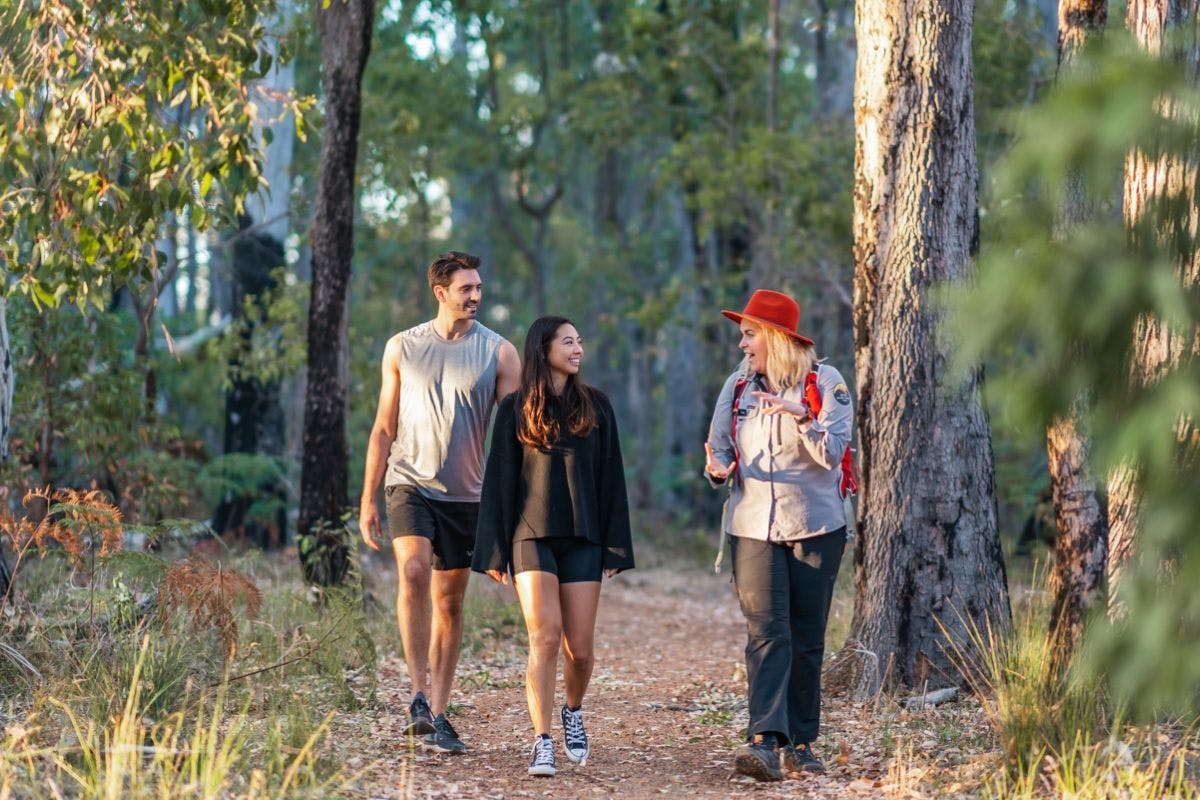 Two people walking through one of the Dwellingup Winter Hikes with a guide